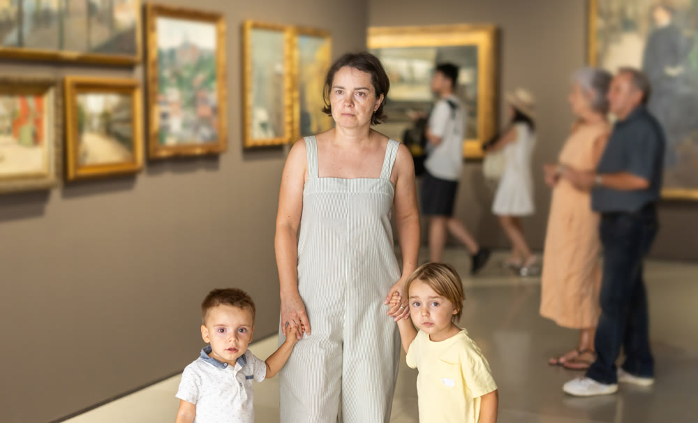 Woman with two children walk around museum hall