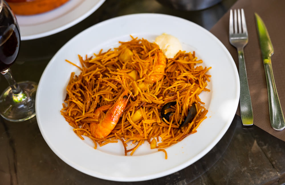 Valencian seafood fideua with mussels, prawns and allioli